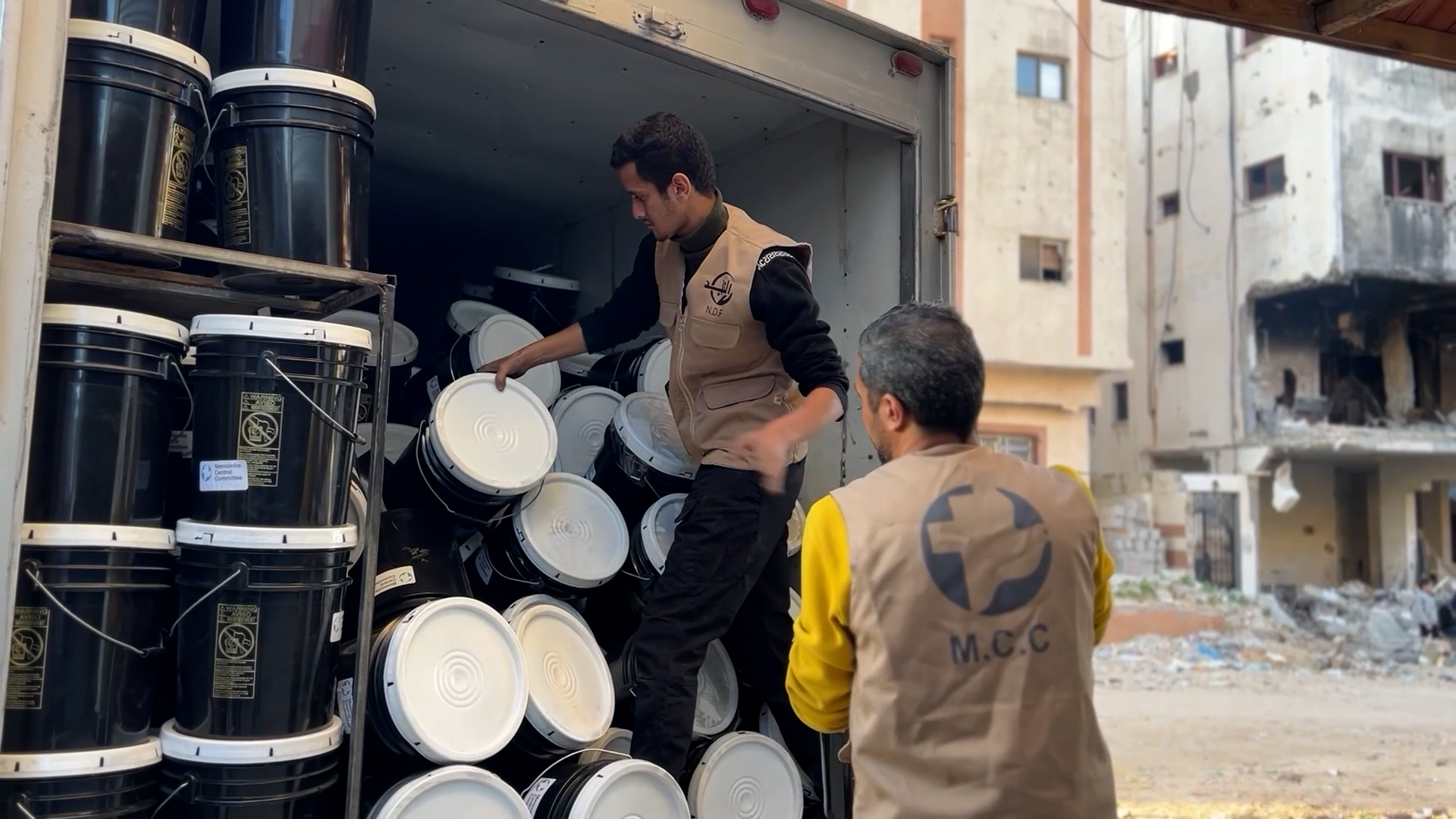 men unloading buckets from truck